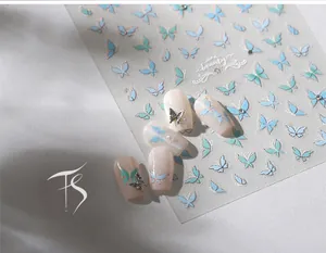 Detailed view of butterfly nail stickers with 3D metal accents and light blue patterns
