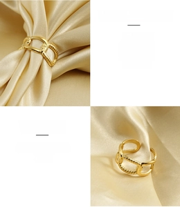Detail of 18k gold plated stainless steel ring with chain and twist texture on silk