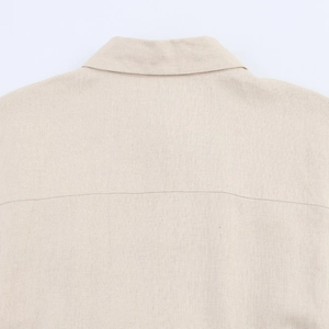 Detail of beige linen shirt dress showing collar back and natural fabric texture