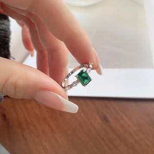Close-up of S925 silver emerald-cut green gemstone ring with side accent diamonds