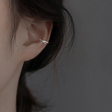 Macro shot of silver crisscross ear bone clip with sparkling zircon stones for women