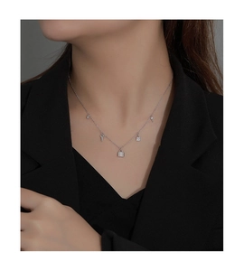 Close-up of 925 silver necklace with lock and key charms worn on a female model