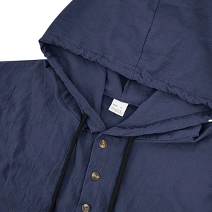 Detail of navy blue linen shirt showing the hood, wooden buttons, and fabric texture