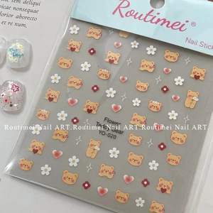 Close-up of nail stickers with flower, teddy bear, and golden heart patterns