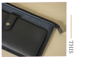 Detail of black leather wallet showing metal zipper and high-quality stitching work