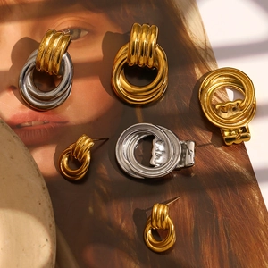Close-up of interlocked two-tone gold and silver stainless steel twisted hoop earrings