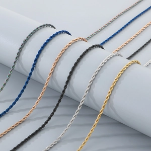 Detail of twisted rope chains in multiple colors hanging on a light grey cylinder stand