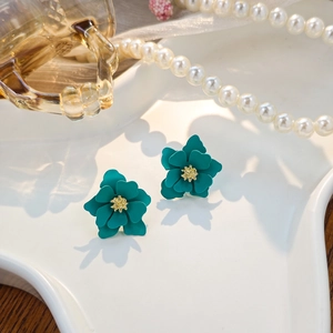 Detail of peacock green layered flower earrings with golden stamen and elegant pearls