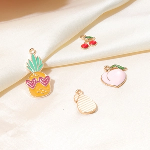 Detail of colorful fruit alloy charms for DIY jewelry including pineapple and peach