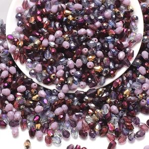 Macro shot of 6x8mm teardrop glass beads in mixed colors spilling from a white bowl