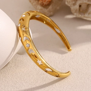 Close-up of 18K gold plated bangle with hollow star moon motifs and embedded zircons