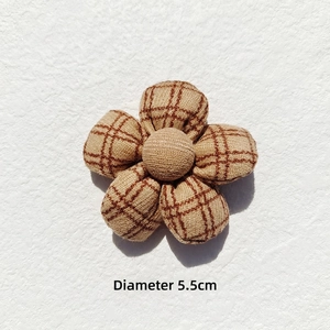 Detail view of 5.5cm plaid fabric flower accessory with measurements on textured background
