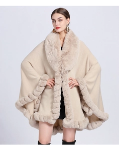Detail of premium faux rabbit fur collar and cuffs on a beige knit oversized poncho