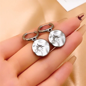Vue détaillée de créoles en argent dotées d'un pendentif motif soleil céleste