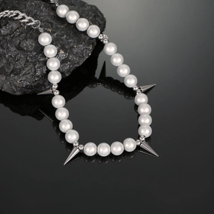 Detailed close-up of reflective pearls and silver spiked pendants on a hip-hop style necklace