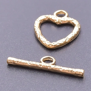 Macro shot of 18k gold plated stainless steel heart OT toggle clasp with textured surface