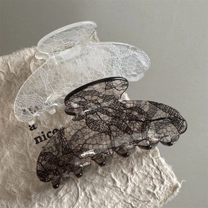 Close-up of hair claw clips with lace pattern texture in white and smoky gray colors