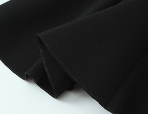 Dettaglio del tessuto in maglia nera ad alta densità per questo top mini abito attillato