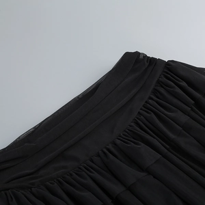 Detailed close-up of pleated black mesh fabric and layered texture on the waist area