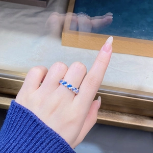 Detailed view of silver ring featuring alternating blue sapphires and round diamonds