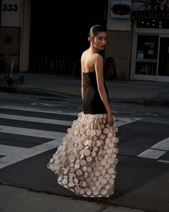Detail of elegant black strapless bodice with flowy polka dot mesh skirt in evening light