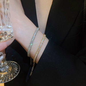 Detail of gold and silver double-row rhinestone bracelets with adjustable metal chains
