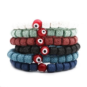 Detailansicht von sechs Lavastein-Armbändern mit roten Perlen des Bösen Blicks