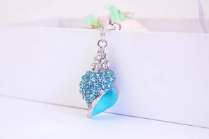 Close-up of ocean-style conch pendant with sparkling blue rhinestones and silver link