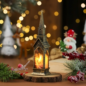 Close-up of bronze church-shaped Christmas lantern with LED candle on a wood base