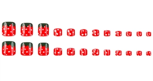 Detail of red strawberry-style press-on toenails with white polka dots and green tips