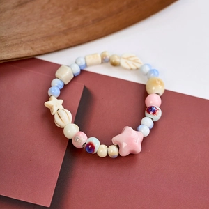 Macro shot of colorful ceramic beads in star and leaf shapes with a glazed finish