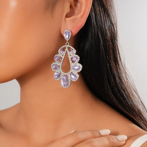 Close-up of luxury teardrop earring with purple stone and shimmering pavé diamonds