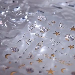 Detailed macro view of 3D shell and star nail art stickers with gold embossed lines