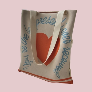Detail of knitted tote bag with orange heart and 'You're the best present ever received' text