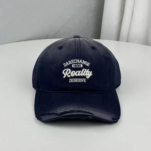 Distressed navy blue baseball cap with white embroidered letters and frayed brim detail.