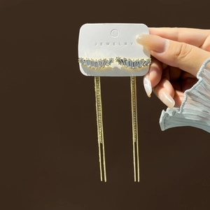 Macro shot of long gold tassel earrings featuring sparkling crystal rhinestones and metal chains