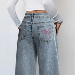 Lichtblauwe jeans met hoge taille en wijde pijpen met roze strikborduursel op de zakken