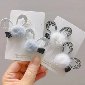 Close-up of fluffy rabbit ear hair clips with rhinestones for kids on a card