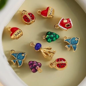 Colorful 3D enamel charms in various shapes on a light tray, stainless steel jewelry