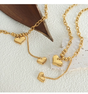 Detailed view of double heart pendants on 18K gold plated titanium steel necklaces