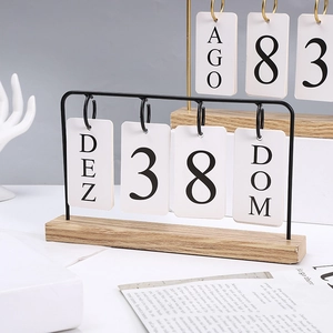 Nordic wooden perpetual calendar with black metal frame and flip cards on desk