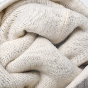 Winterliche cremeweiße Strickmütze aus Wolle mit weicher Textur und feinem Webmuster
