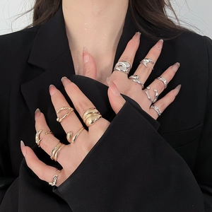 Close-up of stylish gold and silver resin rings with diamond accents and pleated design