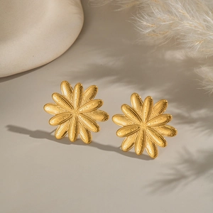 Macro view of golden flower petal earrings with textured stainless steel surface