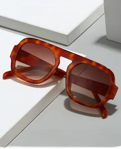 Detail view of tortoiseshell aviator sunglasses on white geometric display stand