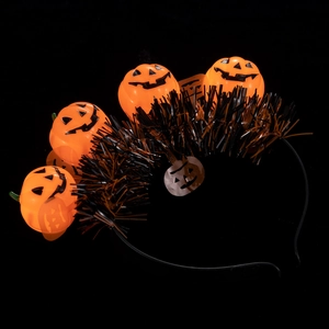 Detail of Halloween headband with orange glowing pumpkins and metallic orange tinsel fringe