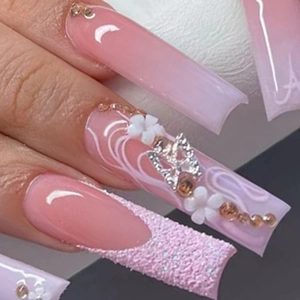 Macro detail of long coffin press-on nails with pink gradient, 3D flowers and silver butterflies