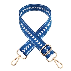 Close-up of blue nylon woven shoulder strap with white chevron pattern and gold metal hooks