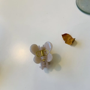 Détail d'une pince à cheveux papillon rose avec ressort métallique sur fond blanc