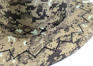 Gros plan d'un chapeau de cowboy camouflage avec surpiqûres et œillets d'aération.